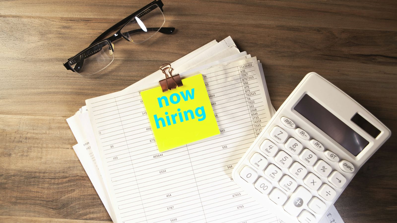 A printed job posting on a desk with several lines underlined in pen
