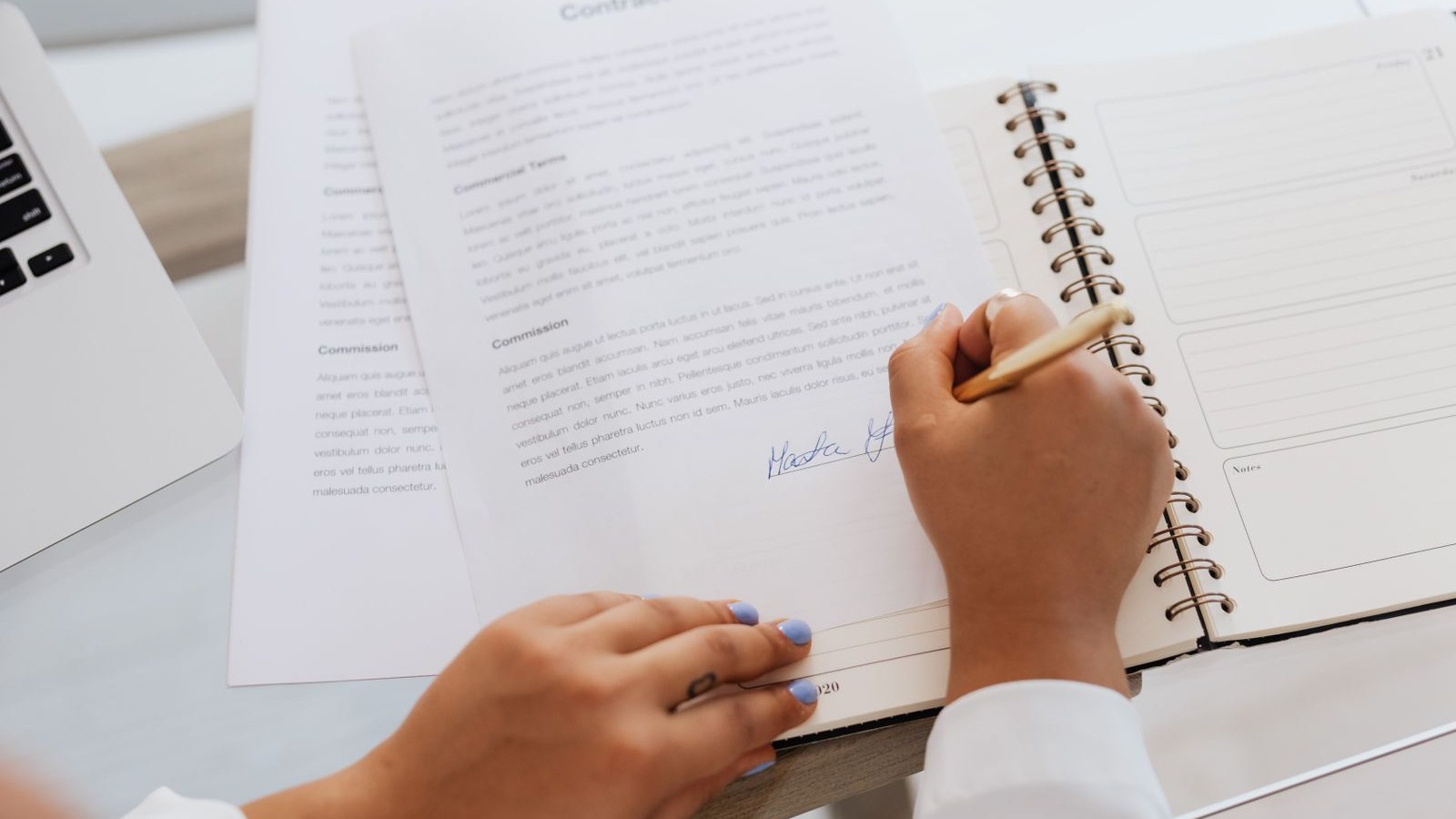 A stapled multi-page agreement and a pen on a kitchen table