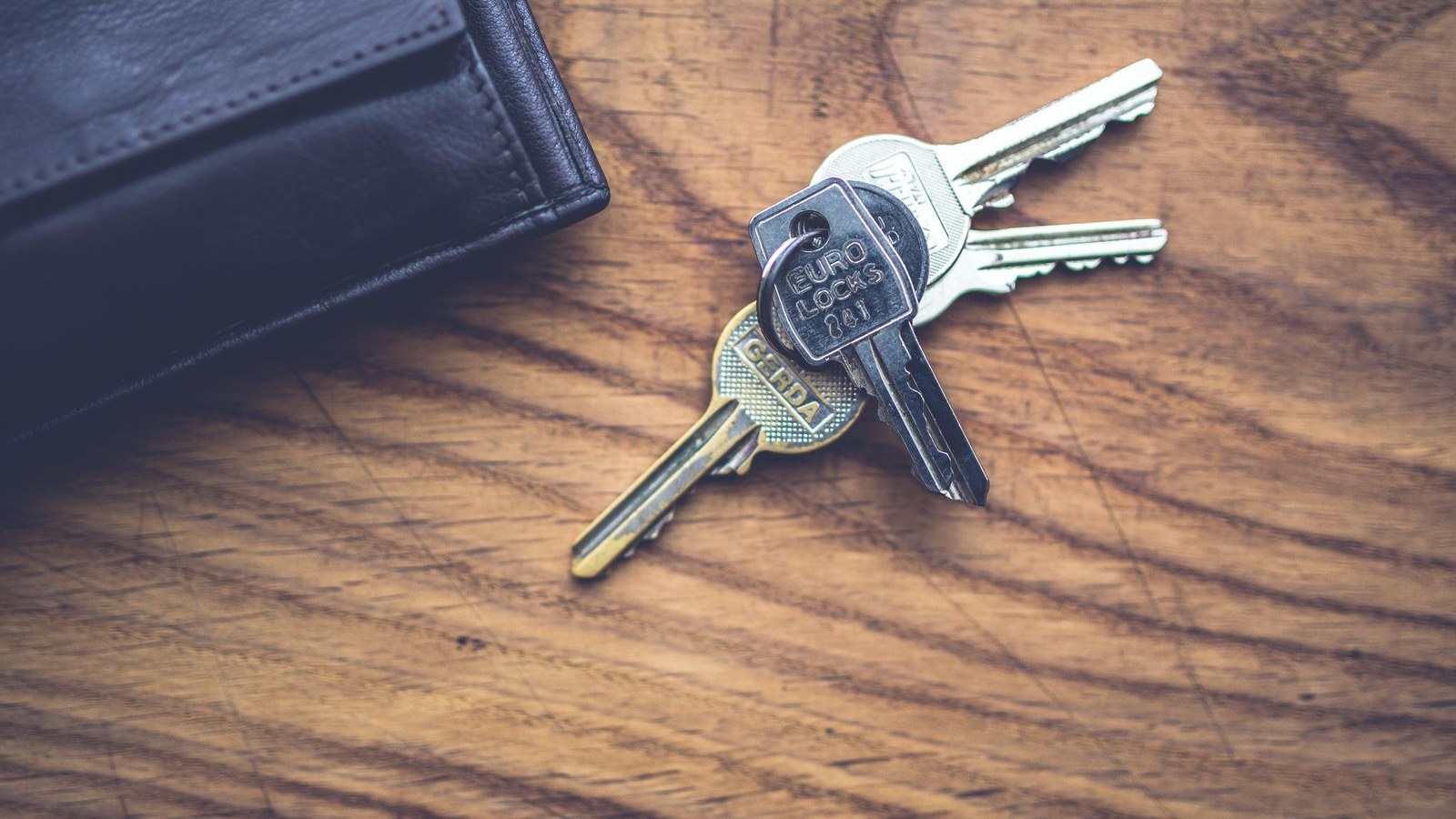 A set of store keys and an alarm fob on a counter beside a closed register drawer