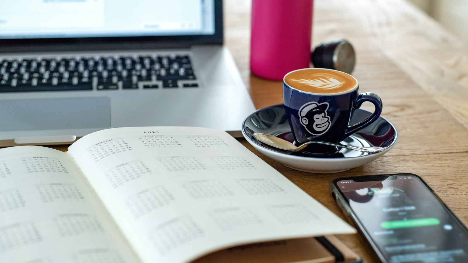 A closed notebook and a phone face down on a small meeting room table