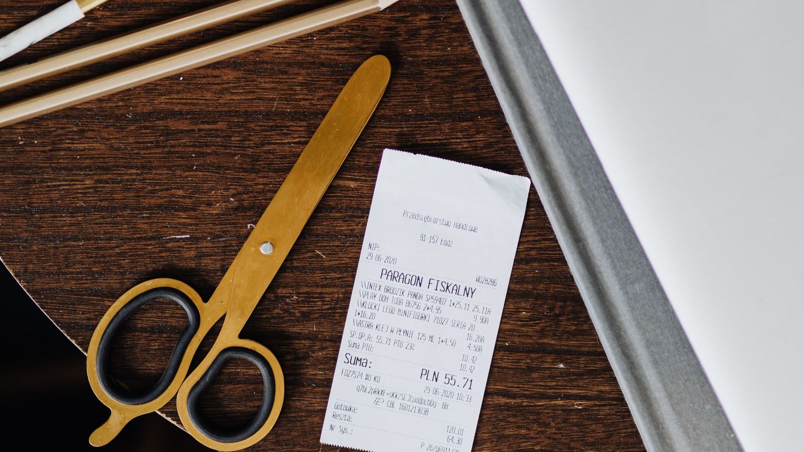 A restaurant check presenter on a table with a printed receipt and a pen